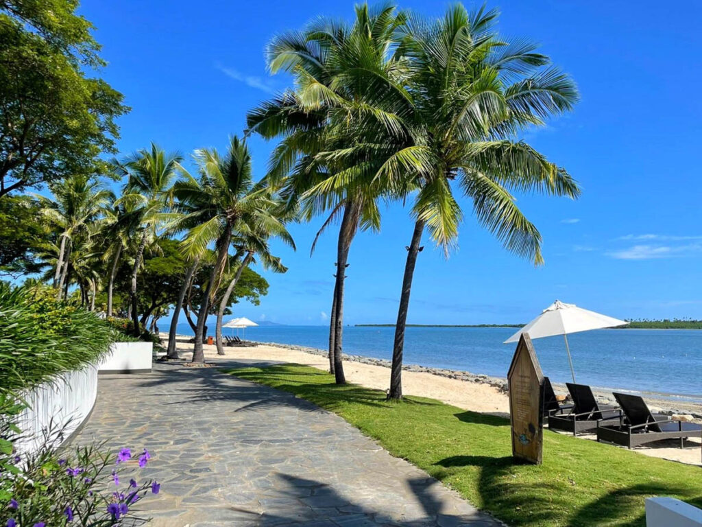 Family resort in Denarau Fiji. Beachside pathway with palm trees.