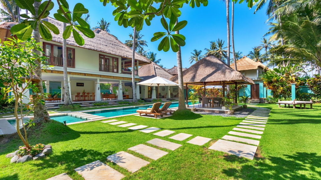 Landscaped gardens of Villa Gils in Bali with swimming pool and villa.