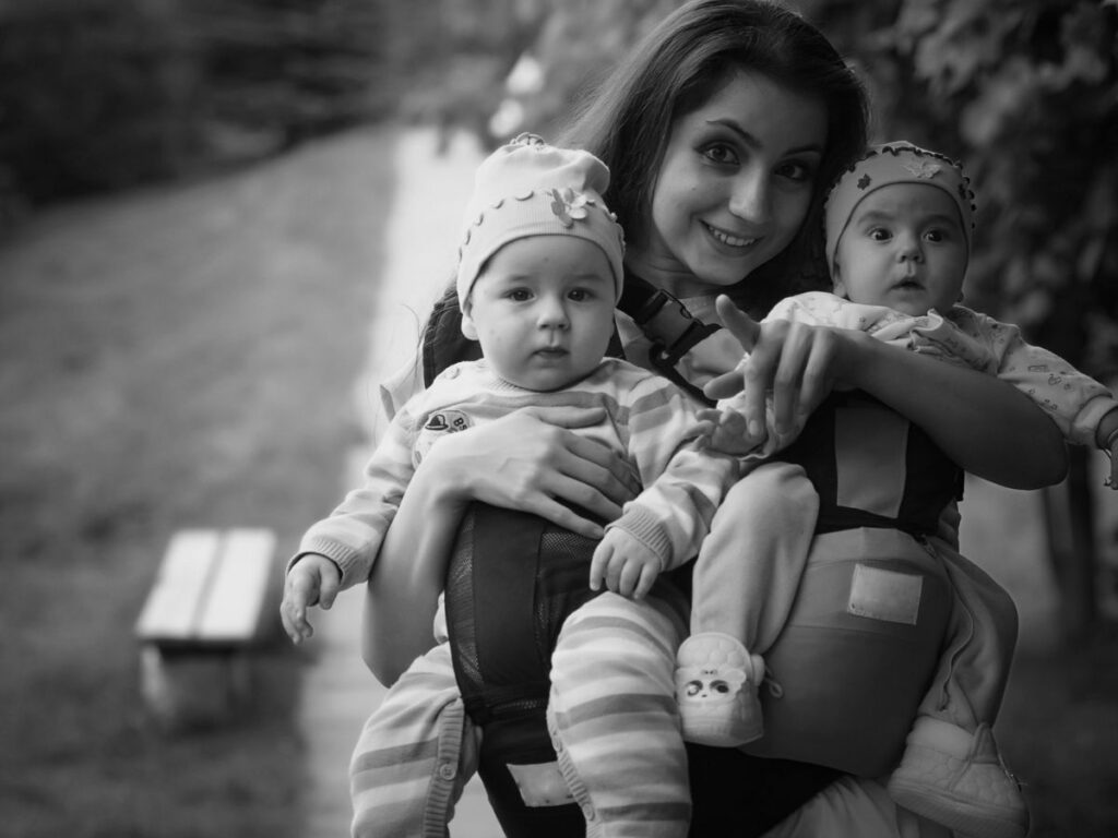Woman with twins in a baby carrier