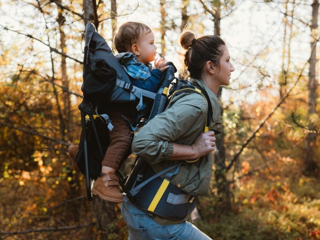 Woman carrying baby in backpack carrier hiking