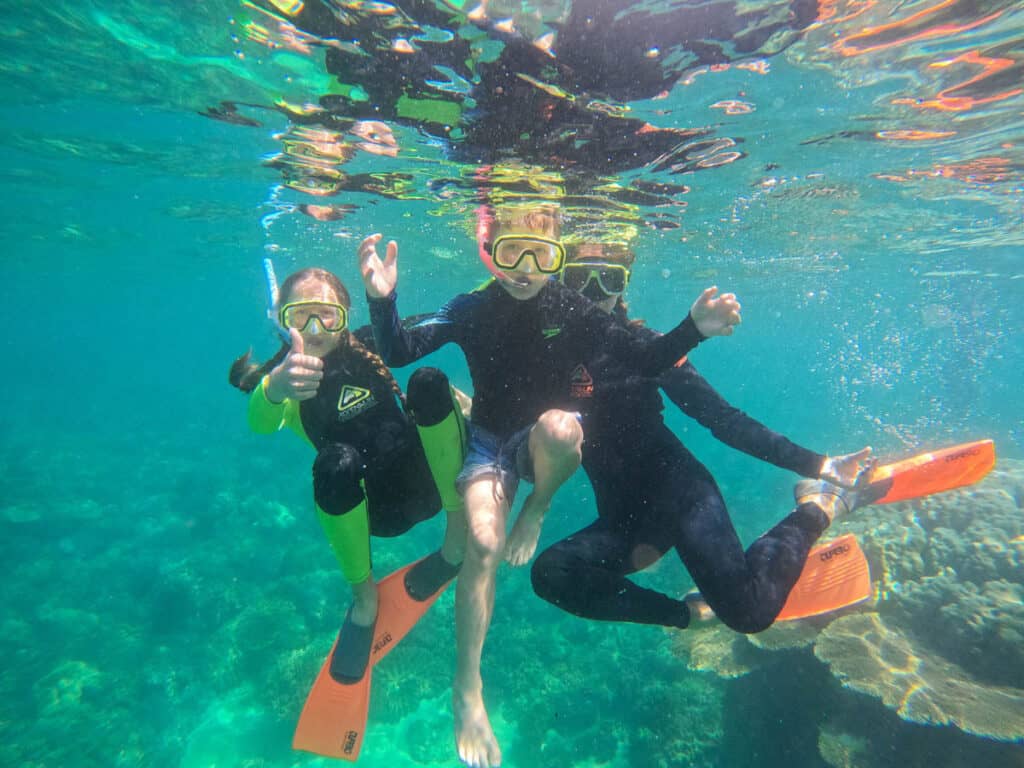 Mum and kids snorkelling underwater.