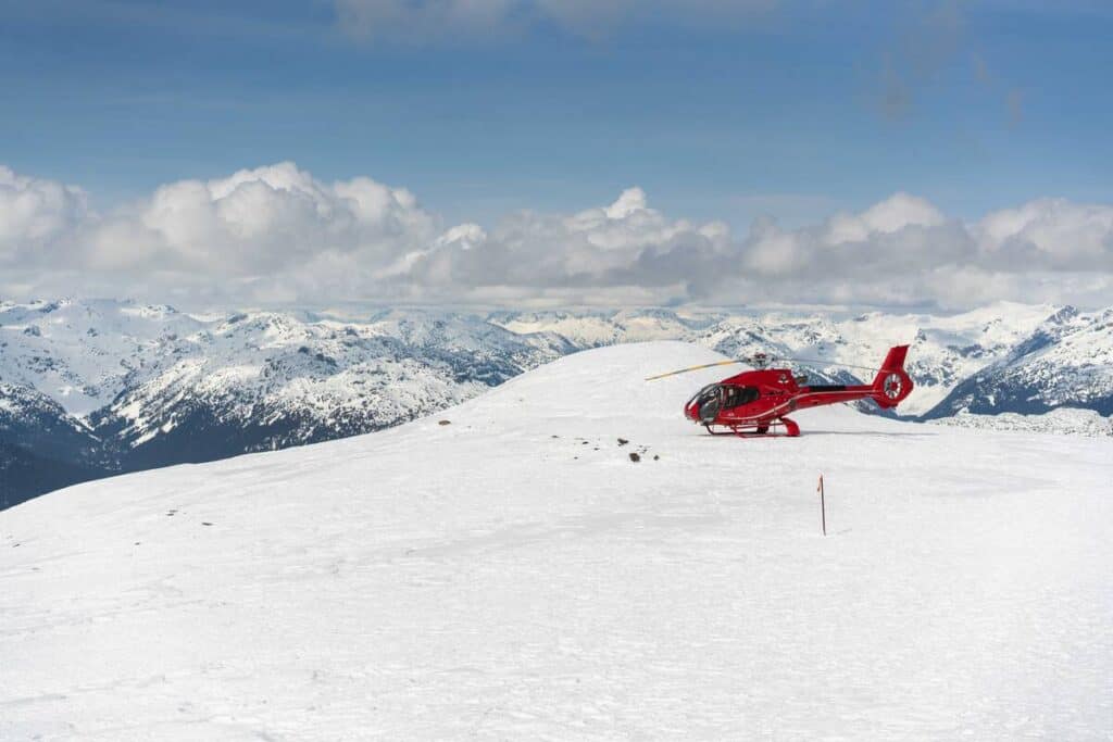 Helicopter landed on snowy mountain. 
