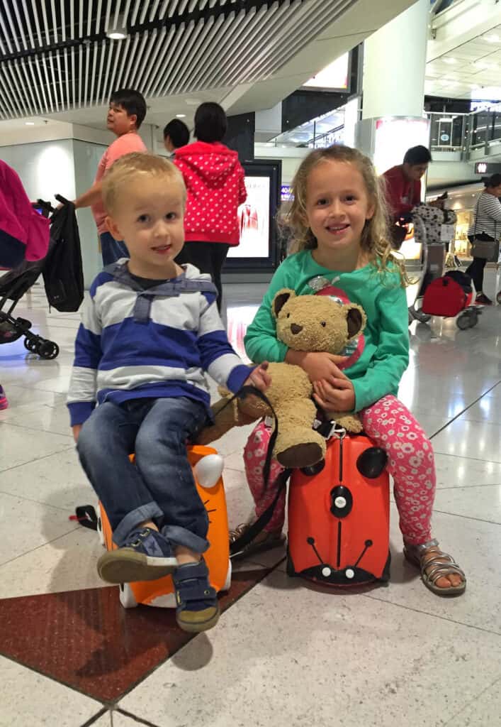 Kids on Trunki Ride on suitcases in airport. 