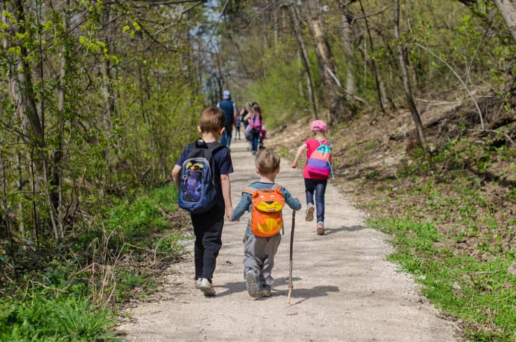 Kids hiking along a trail. 