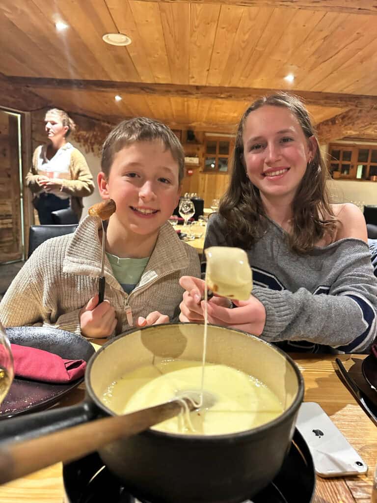 Kids with fondue in restaurant in Tignes.
